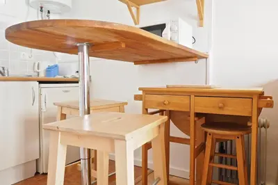 a kitchen with a wooden table and a table and stool at Sunny Apartments Barcelona in Barcelona