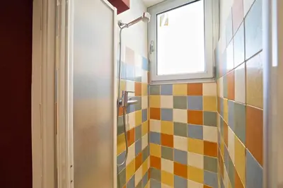 a bathroom with a shower with a window and colorful tiles at Sunny Apartments Barcelona in Barcelona