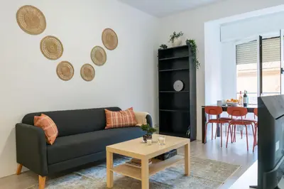 a living room with a black couch and a table at Orange crush Barcelona in Barcelona