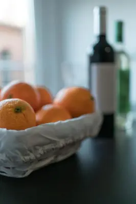 a bowl of oranges on a table with a bottle of wine at Orange crush Barcelona in Barcelona
