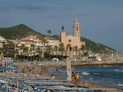 a beach with a bunch of boats on the water at Apartamentospedroche Sitges in Sitges