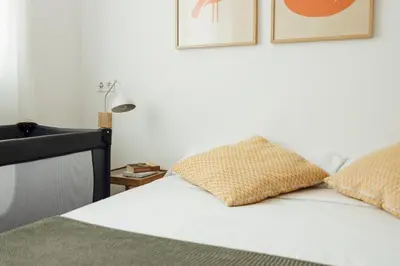 a white bed with two pillows on top of it at Casa Jam Barcelona in Barcelona