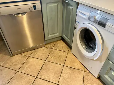 a washer and dryer in a kitchen with a tile floor at Coast apartment near Barcelona in Sant Andreu de Llavaneres
