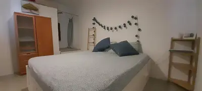 a bedroom with a bed with blue pillows and a shelf at Mediterranien Terrace in Calella