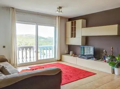 a living room with a couch and a large window at Villa Papallona by Hello Homes Sitges in Sant Pere de Ribes