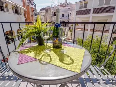 a glass table on a balcony with a bottle and glasses at Espalter Onyx by Hello Homes Sitges in Sitges