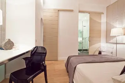 a bedroom with a bed and a chair in a room at Cathedral Apartment in Barcelona