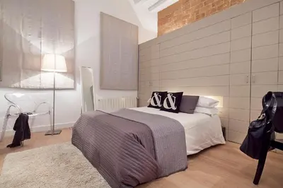 a bedroom with a bed and a brick wall at Cathedral Apartment in Barcelona