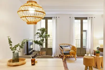 a living room with a table and a chandelier at Columbus Apartment in Barcelona
