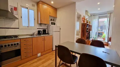 a kitchen with a table and chairs in it at Àtic Trobador in Barcelona
