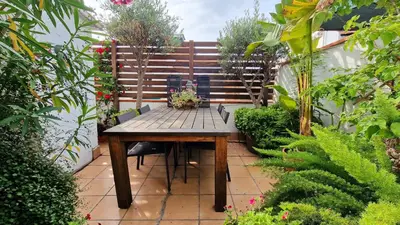 a wooden table and chairs in a garden at Àtic Trobador in Barcelona
