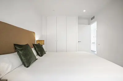 a bedroom with a large white bed with green pillows at CATERINA Santa Mònica in Barcelona