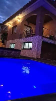 a large house with a blue pool in front of it at Casa rustica con piscina y jardin in Pineda de Mar