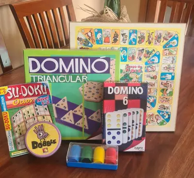 a box of dominoes and other toys on a table at Casa rustica con piscina y jardin in Pineda de Mar