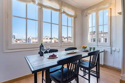 a dining room with a table and chairs and windows at Habitat Apartments Bailén in Barcelona