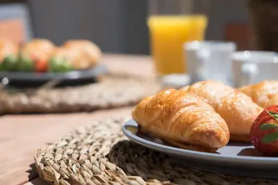 a plate of croissants and an apple on a table at Habitat Apartments Bailén in Barcelona