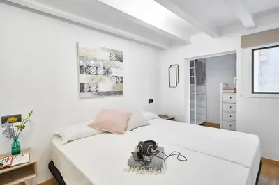 a bedroom with a white bed with a camera on it at BeBarceloner Eixample Duplex Apartments in Barcelona