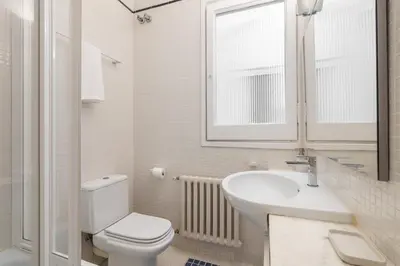 a white bathroom with a toilet and a sink at Balmes Apartment by Olala Homes in Barcelona