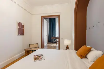 a bedroom with a large white bed and a table at Balmes Apartment by Olala Homes in Barcelona