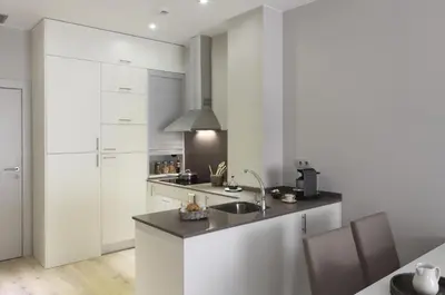 a kitchen with white cabinets and a sink at Rambla 102 in Barcelona