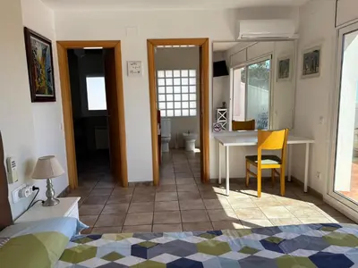 a room with a bed and a desk and a table at Olivella Bed&breakfast in Olivella