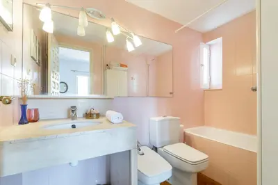 a bathroom with a sink and a toilet and a mirror at Paola: Preciosa casa pareada con piscina in Sitges