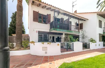a house with a balcony and a yard at Paola: Preciosa casa pareada con piscina in Sitges