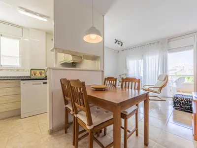 a kitchen and dining room with a wooden table and chairs at Apartment Girona by Interhome in Cubelles