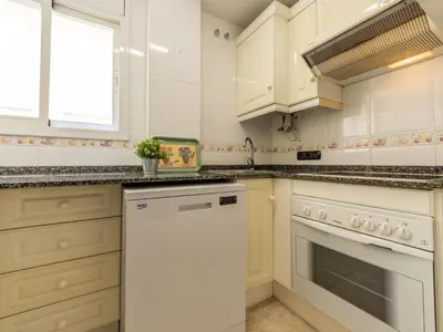 a kitchen with white cabinets and a white dishwasher at Apartment Girona by Interhome in Cubelles