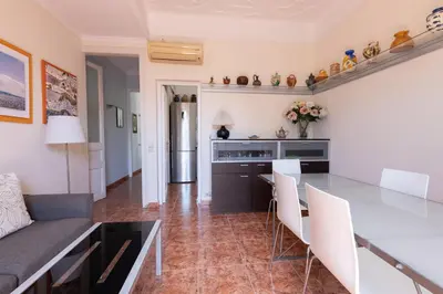 a kitchen and living room with a table and chairs at ApartEasy - Modernist flat in Eixample center in Barcelona