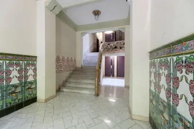 a hallway with a staircase with colorful tiles at ApartEasy - Modernist flat in Eixample center in Barcelona