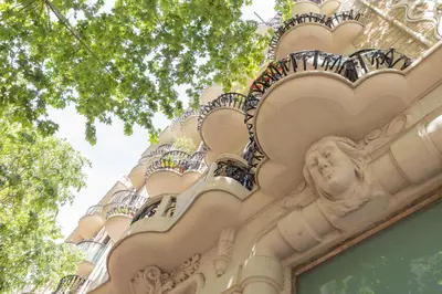 a building with a statue on the side of it at ApartEasy - Modernist flat in Eixample center in Barcelona