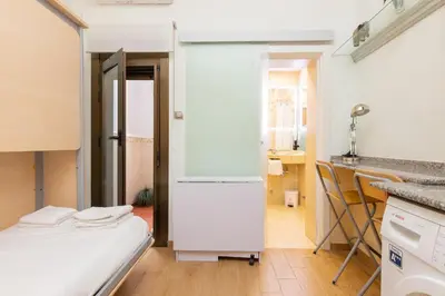 a kitchen with a white refrigerator in a room at ApartEasy - Central Barcelona Studio Apartment in Barcelona