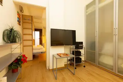 a living room with a tv and a table in a room at ApartEasy - Central Barcelona Studio Apartment in Barcelona