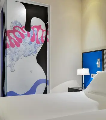 a bedroom with a bed and a painting on the door at H10 Art Gallery 4* Sup in Barcelona