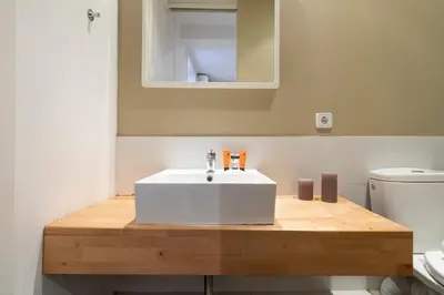 a bathroom with a white sink and a toilet at AB Eixample Miró Park in Barcelona