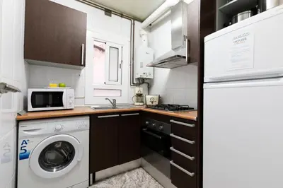 a small kitchen with a washer and dryer in it at AB Eixample Miró Park in Barcelona