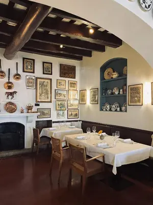 a dining room with two tables and a fireplace at Hostal de la Plaça - Hotel Boutique in Cabrils