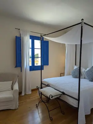 a bedroom with a canopy bed and a couch at Hostal de la Plaça - Hotel Boutique in Cabrils