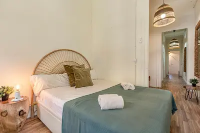 a bedroom with a large bed with a green blanket at Aragó Suites in Barcelona