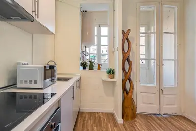 a kitchen with a counter with a microwave and a window at Aragó Suites in Barcelona