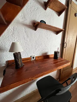 a wooden shelf on a wall with a chair and a lamp at Casita rural con piscina in La Torre de Claramunt