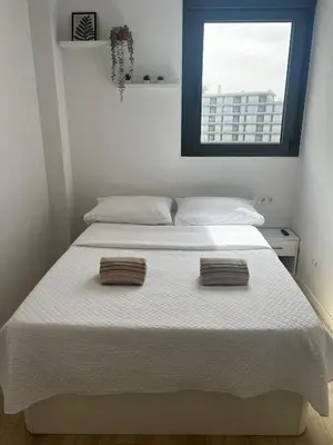 a bedroom with a white bed with two towels on it at Confortable habitación doble - 2 in Sant Adria de Besos