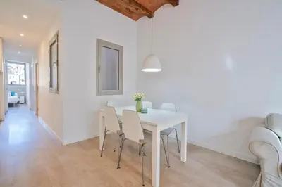 a white dining room with a white table and chairs at BcnStop Sant Pau Suites in Barcelona