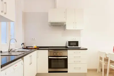 a white kitchen with a sink and a microwave at 1554 - AB Passeig de Gràcia Pelai in Barcelona