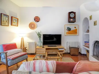 a living room with a couch and a tv at Red Velvet Apartment by Hello Homes Sitges in Sitges
