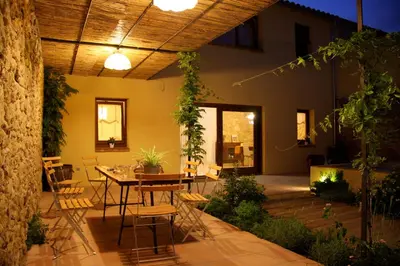 a patio with a table and chairs in a house at Ca l'Helena in Castellet