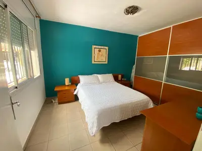 a bedroom with a bed and a blue wall at Le Petit Paradis Olivella in Olivella