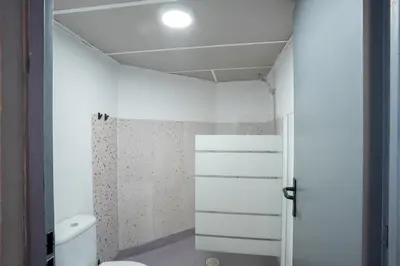 a white bathroom with a toilet and a shower at Malacuna Barcelona in Barcelona