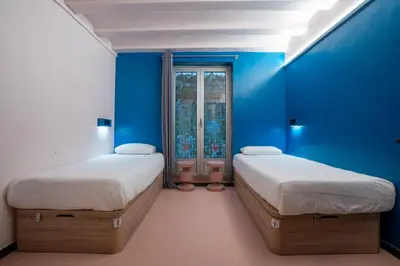 two beds in a room with blue walls at Malacuna Barcelona in Barcelona